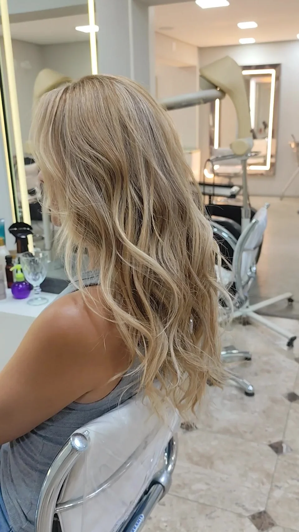 Cabelo loiro longo com ondas e reflexos, visto de costas